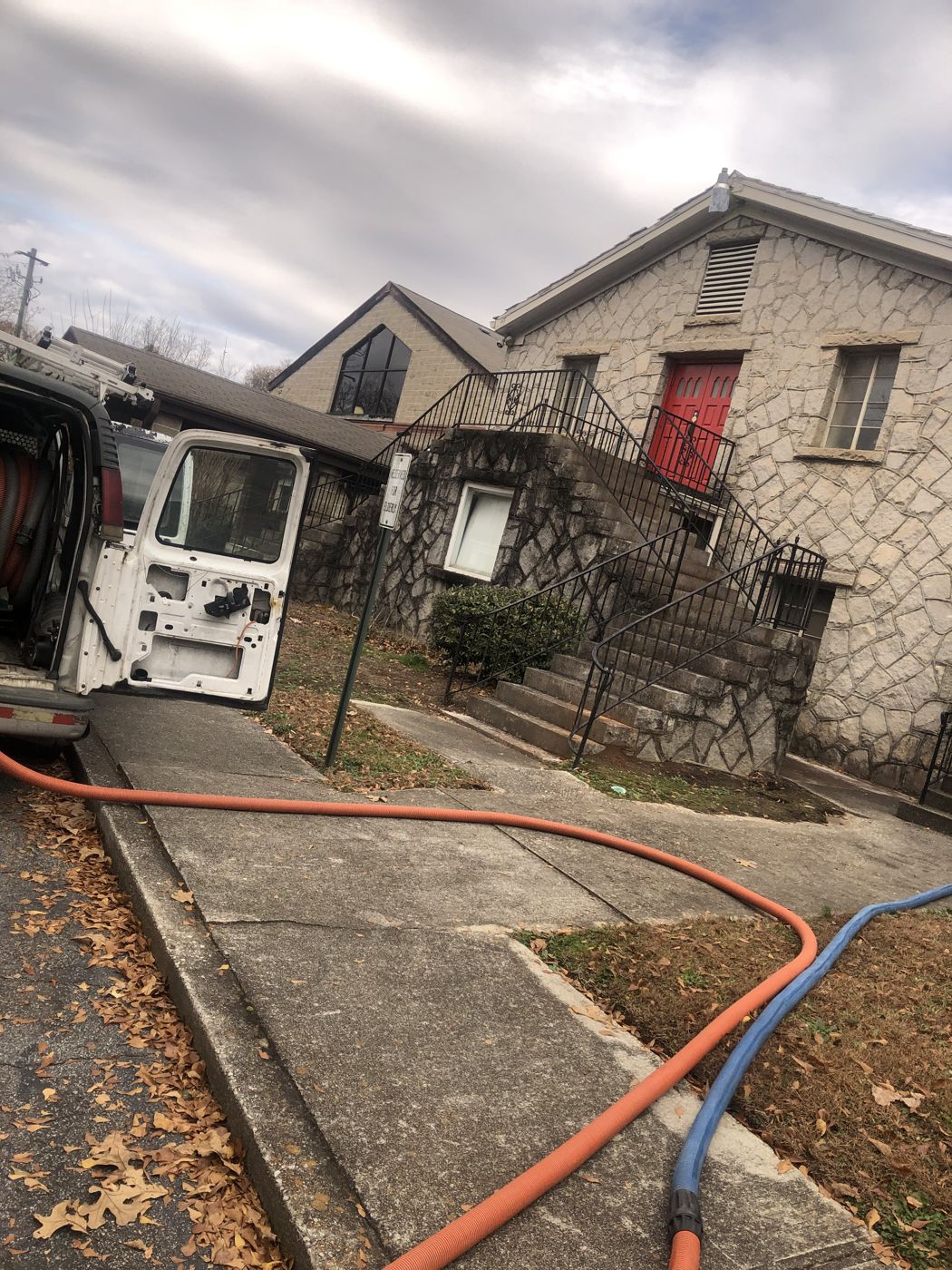 The DCA service van parked at a customer's building with solution and vacuum hoses run to the door